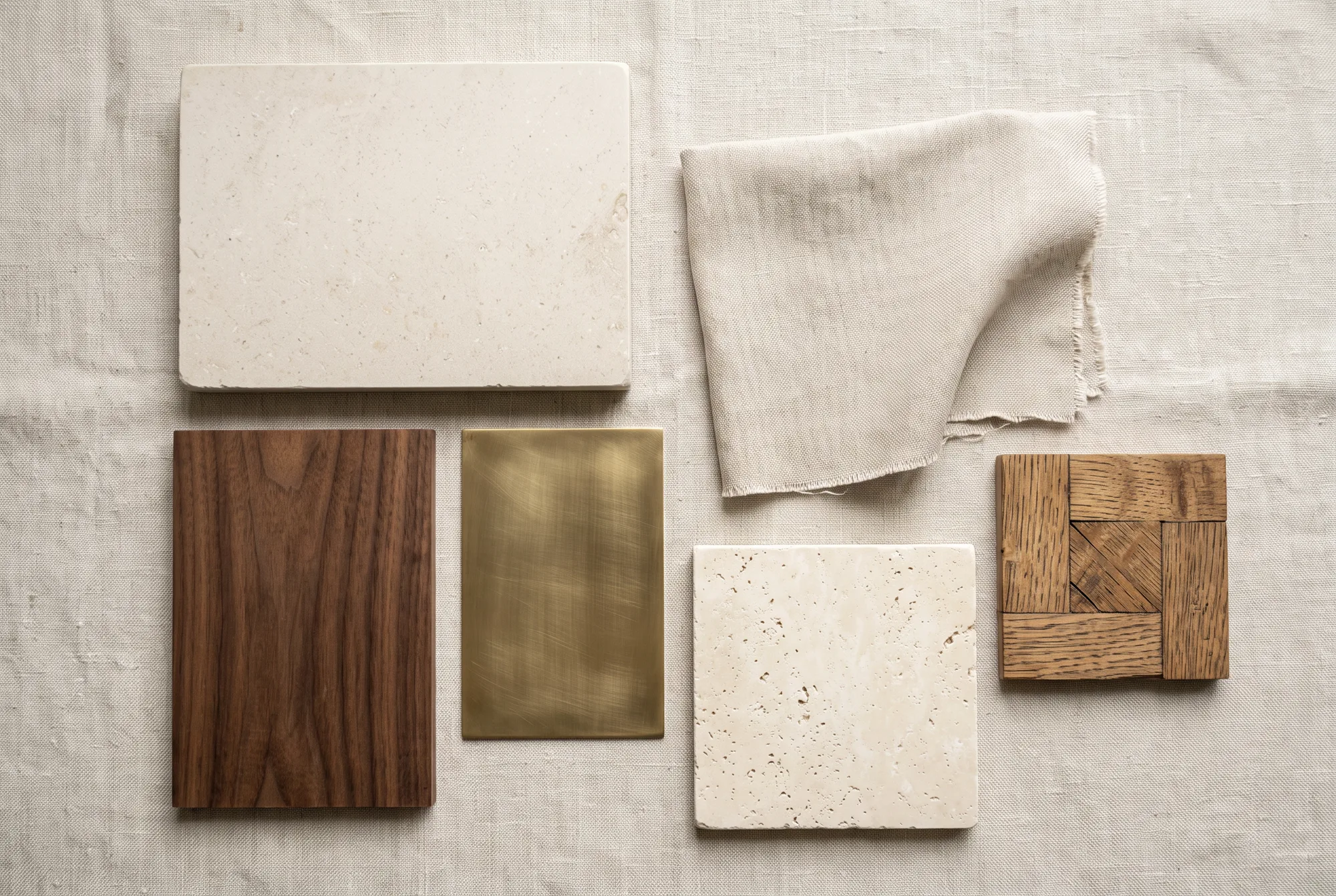 Materialmuster: Kalkstein, Nussbaum, Messing und Leinen